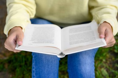 Park yerinde kitap okuyan kadın, yakın çekim görüntüsü