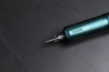 Siyah masadaki dövme makinesi, yakın plan. Metin için boşluk