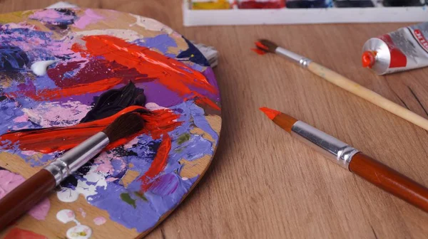 Ahşap Masa Üzerinde Karışık Boya Fırçalarla Sanatçı Paleti — Stok fotoğraf