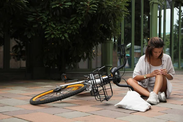Молодая Женщина Травмой Колена Возле Велосипеда Городской Улице Пространство Текста — стоковое фото