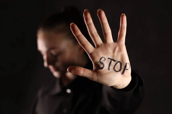Kvinna Med Ord Stopp Skrivet Hand Mot Mörk Bakgrund Närbild — Stockfoto