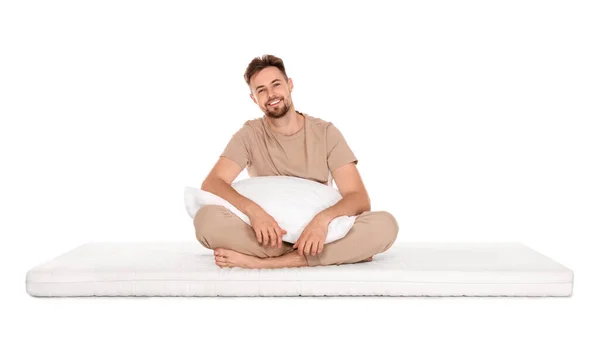 Sorrindo Homem Com Travesseiro Sentado Colchão Macio Contra Fundo Branco — Fotografia de Stock