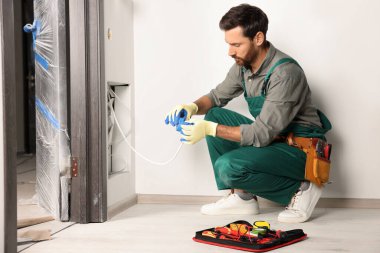 Elektrikçi kabloları kapalı alanda yalıtım bandıyla onarıyor.