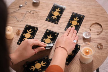 Kahin, tahtadan masadaki tarot kartlarıyla geleceği tahmin ediyor. Yakın plan.