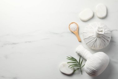 Beyaz mermer masanın üzerinde farklı spa ürünleri bulunan düz bir kompozisyon. Metin için boşluk