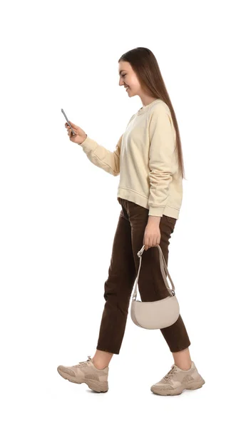 Jovem Mulher Roupa Casual Usando Smartphone Enquanto Caminha Sobre Fundo — Fotografia de Stock