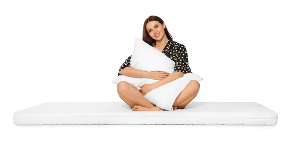 坐在软垫上抱着枕头的年轻女子 背景是白色的 — 图库照片