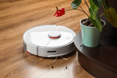 İçerideki ahşap zeminden gelen robotik elektrik süpürgesi.