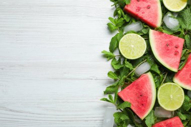 Lezzetli dilimlenmiş karpuz, limon, nane ve buz beyaz ahşap masada, düz yerde. Metin için boşluk