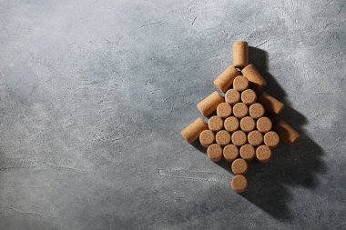 Gri masadaki şarap mantarlarından yapılmış Noel ağacı, üst manzara. Metin için boşluk