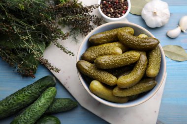 Taze ve turşulu salatalıklar, açık mavi ahşap masa üzerinde malzemeler, düz yatıyordu.