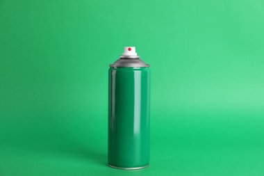 Yeşil arka planda renkli sprey boya kutusu