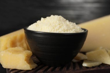 Bowl with grated parmesan cheese on table, closeup