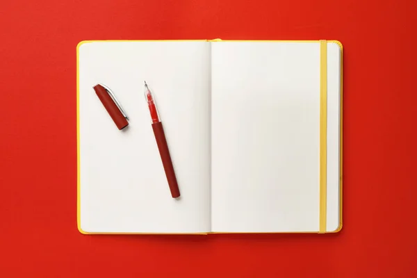 Zápisník Pero Červeném Pozadí Horní Pohled — Stock fotografie