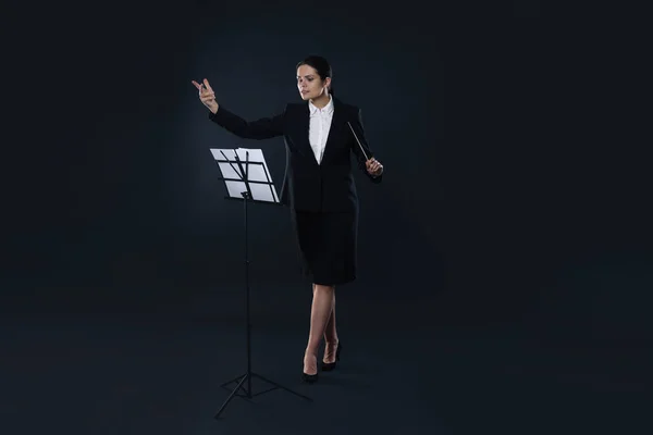 stock image Professional conductor with baton and note stand on dark background