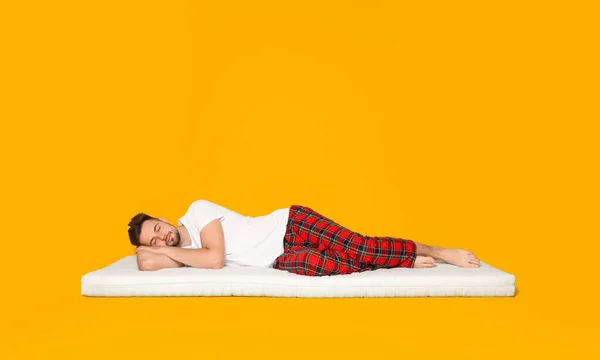 Uomo Che Dorme Materasso Morbido Contro Sfondo Arancione — Foto Stock