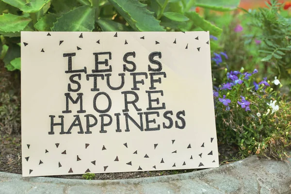 stock image Card with phrase Less Stuff More Happiness on stone planter outdoors