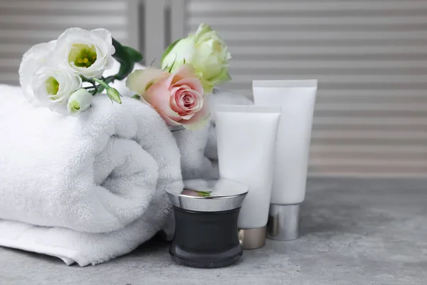 Handtücher Kosmetikprodukte Und Blumen Auf Grauem Tisch Drinnen — Stockfoto