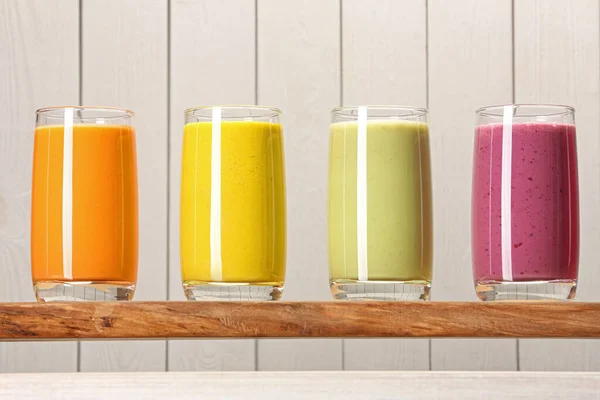 Bord Met Veel Verschillende Lekkere Smoothies Tegen Witte Houten Achtergrond — Stockfoto