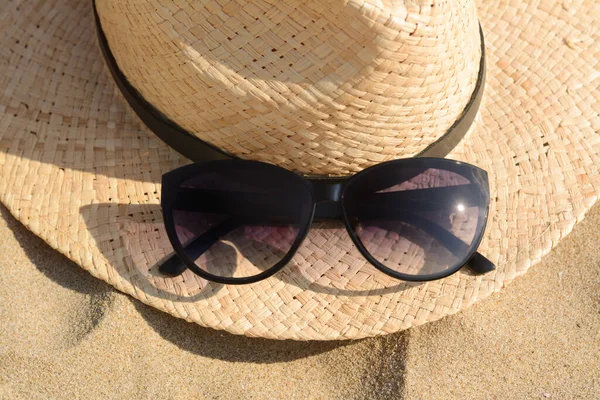stock image Hat with beautiful sunglasses on sand, closeup