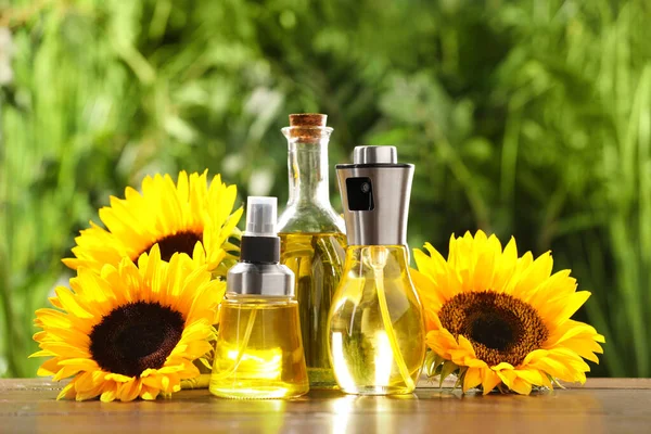Sonnenblumen Und Viele Verschiedene Flaschen Mit Speiseöl Auf Holztisch Vor — Stockfoto