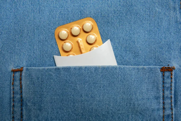 Birth control pills in pocket of jeans, closeup