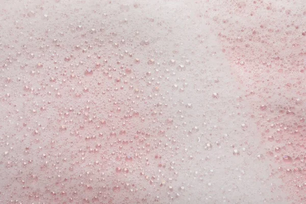 ピンクの背景にふわふわの石鹸泡 クローズアップ — ストック写真