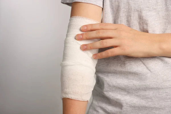 Woman Arm Wrapped Medical Bandage Light Grey Background Closeup Space — Stock Photo, Image