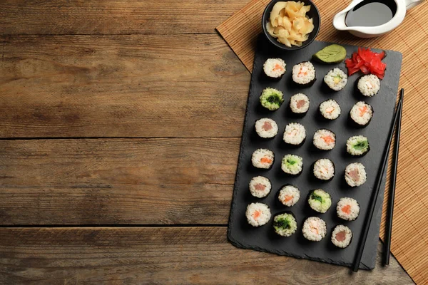 味道鲜美的寿司卷放在木制桌子上 平铺在地板上 案文的篇幅 — 图库照片