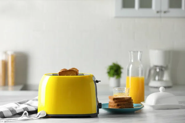 黄色烤面包机 烤面包片 橙汁放在白色大理石桌上 — 图库照片