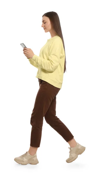 Νεαρή Γυναίκα Casual Outfit Χρησιμοποιώντας Smartphone Ενώ Περπατάτε Λευκό Φόντο — Φωτογραφία Αρχείου