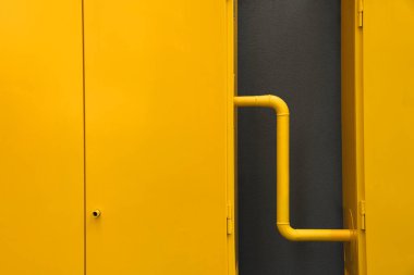 Kahverengi duvarın yanında sarı gaz dağıtım dolabı