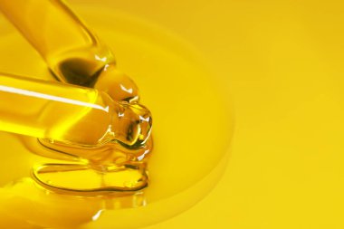 Aynadaki pipetlerden serumu damlatıyor, sarı tonda. Metin için alanı olan kapatma