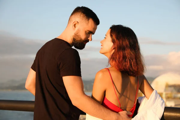幸せな若いカップル抱擁で海堤防 — ストック写真