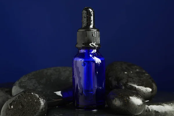 Μπουκάλι Ορού Προσώπου Υγρές Πέτρες Spa Μπλε Φόντο Closeup — Φωτογραφία Αρχείου