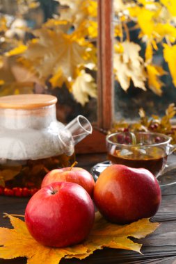 Sıcak çay, elma ve kuru yapraklar ahşap pencere eşiğinde. Sonbahar atmosferi