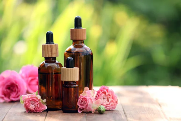 Bottles Rose Essential Oil Flowers Wooden Table Outdoors Space Text — Foto de Stock