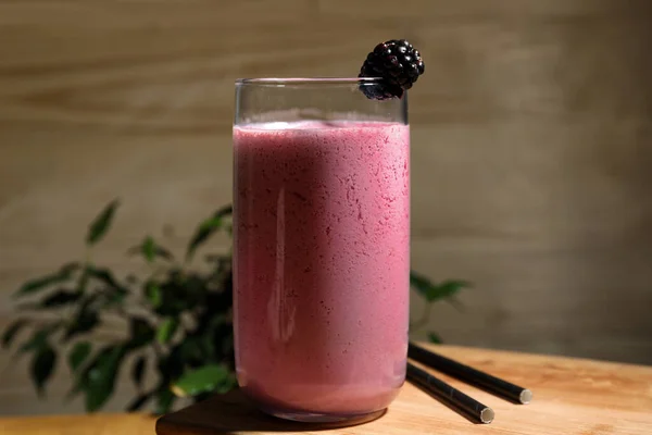 stock image Glass of blackberry smoothie on wooden table