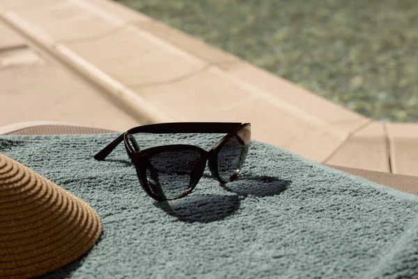 Stylowe Okulary Przeciwsłoneczne Wieczko Niebieskim Ręczniku Pobliżu Odkrytego Basenu Zbliżenie — Zdjęcie stockowe