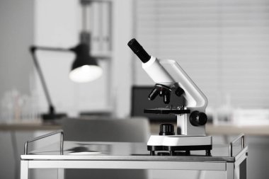 Modern medical microscope on metal table in laboratory, space for text