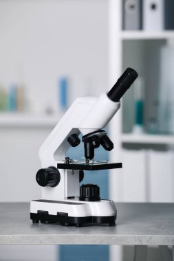 Modern medical microscope on grey table in laboratory