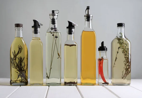 Bottles Different Cooking Oils White Wooden Table Grey Background — Stockfoto