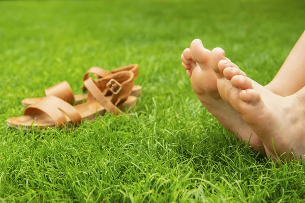 Žena Odpočívající Bosa Blízkosti Sandálů Zelené Trávě Venku Detailní Záběr — Stock fotografie