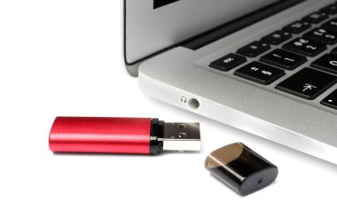 Beyaz arkaplanda dizüstü bilgisayarın yanında Usb flash diski