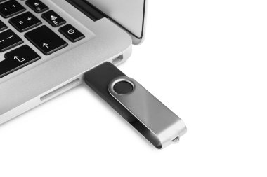 Modern USB flaş bellek beyaz arkaplanda dizüstü bilgisayara bağlandı, yakın plan