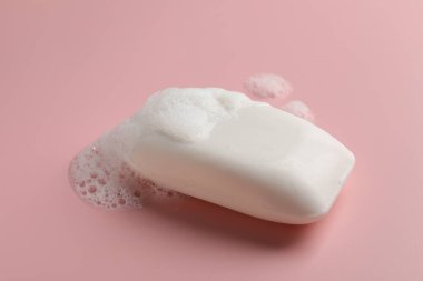 Pembe arka planda köpüklü sabun.