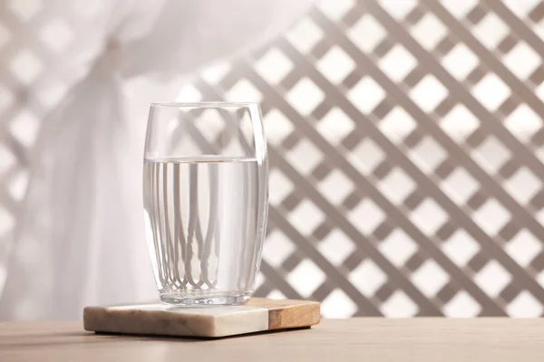 背景がぼやけている木製のテーブルの上の純水のガラス テキストのためのスペース — ストック写真