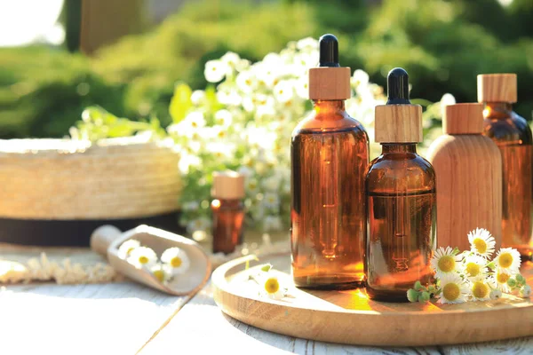 Bottles Essential Oil Flowers White Wooden Table Outdoors Space Text — Stockfoto