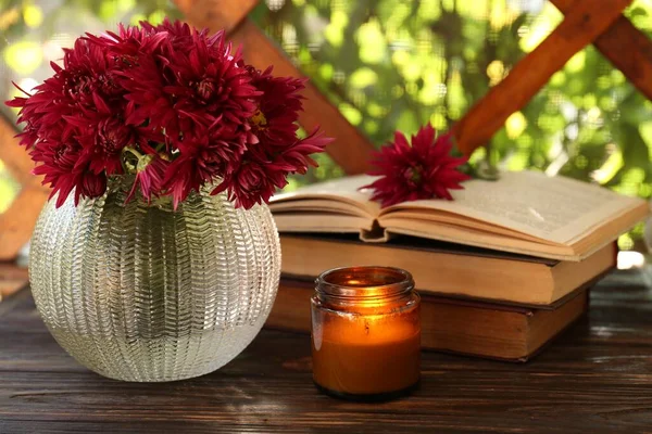 Όμορφα Ροζ Χρυσάνθεμα Λουλούδια Αναμμένο Κερί Και Βιβλία Ξύλινο Τραπέζι — Φωτογραφία Αρχείου