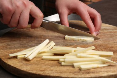 Siyah masada nefis taze olgun yaban havucu kesen kadın, yakın plan.